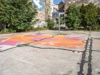 a basketball court painted with an orange and pink butterfly on it in the parking lot