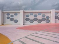 a garage with pink walls and blue windows on a cloudy day with sky clouds above