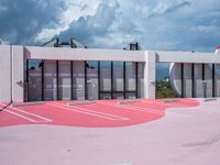 red and white painted parking lot for the outside of a building with gray and black clouds above