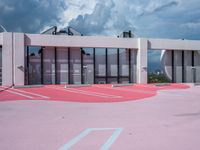 red and white painted parking lot for the outside of a building with gray and black clouds above