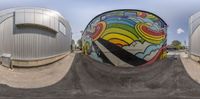 a fish eye view of some gas storage containers with graffiti on the wall and one in front