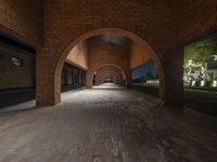 an archway that is in an empty building with stone and brick arches in between it