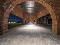 an archway that is in an empty building with stone and brick arches in between it