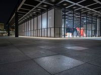 the glass entrance to a very modern building at night time in tokyo, japan near the city center