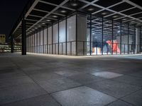 the glass entrance to a very modern building at night time in tokyo, japan near the city center