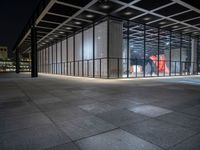 the glass entrance to a very modern building at night time in tokyo, japan near the city center