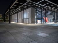 the glass entrance to a very modern building at night time in tokyo, japan near the city center