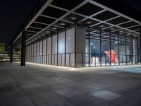 the glass entrance to a very modern building at night time in tokyo, japan near the city center