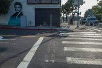 a woman walking across the street in front of a store entrance and a traffic light