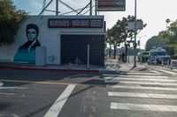 a woman walking across the street in front of a store entrance and a traffic light