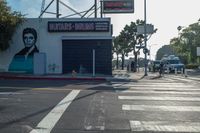 a woman walking across the street in front of a store entrance and a traffic light