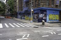 a cross walk with lots of graffiti painted on the walls of it and a building