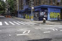 a cross walk with lots of graffiti painted on the walls of it and a building