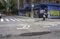 a cross walk with lots of graffiti painted on the walls of it and a building