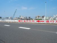 a traffic lane with buildings in the background with an red arrow pointing to two opposite directions