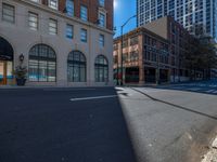 the empty street is next to some building and there are no cars passing through it