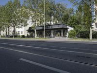 a bus parked on the side of the street in front of a building and many trees