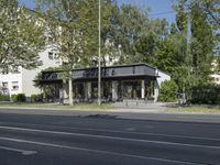 a bus parked on the side of the street in front of a building and many trees