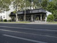 a bus parked on the side of the street in front of a building and many trees