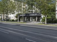 a bus parked on the side of the street in front of a building and many trees