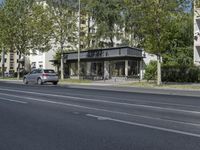 a bus parked on the side of the street in front of a building and many trees