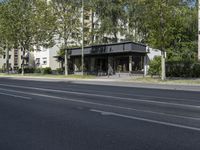 a bus parked on the side of the street in front of a building and many trees