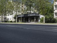 a bus parked on the side of the street in front of a building and many trees