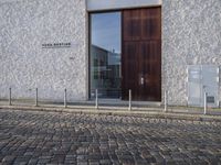 a dog is outside a store with glass doors and windows on either side of it