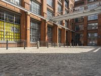 a brick courtyard outside the building with a horse statue behind glass doors and windows on the outside