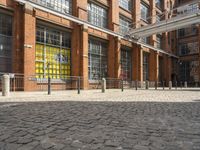 a brick courtyard outside the building with a horse statue behind glass doors and windows on the outside