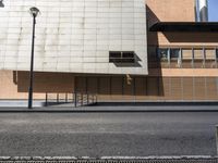 a building sitting on the side of a road with a parking meter and lamp post