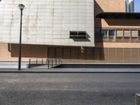 a building sitting on the side of a road with a parking meter and lamp post