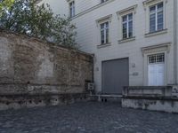 there is a bench and a door near a large building with windows in the back