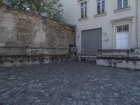 there is a bench and a door near a large building with windows in the back