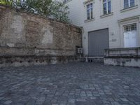 there is a bench and a door near a large building with windows in the back