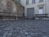 there is a bench and a door near a large building with windows in the back