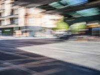 a street with two trains on it and a few people walking under an overpass