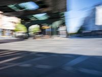 a street with two trains on it and a few people walking under an overpass