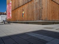 a group of people riding skateboards near wooden panels and stairss with artwork on them