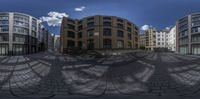 this is a 360 - view photo of a street from a fisheye lens with buildings around it