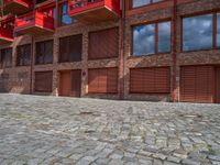 the courtyard area of a building has a small fire hydrant and brick walkways on each side