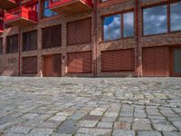 the courtyard area of a building has a small fire hydrant and brick walkways on each side