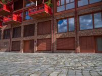 the courtyard area of a building has a small fire hydrant and brick walkways on each side