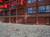 the courtyard area of a building has a small fire hydrant and brick walkways on each side