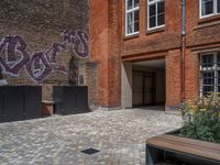 several plants sit in decorative concrete planters along the sidewalk of a building that is very modern