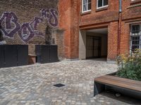 several plants sit in decorative concrete planters along the sidewalk of a building that is very modern