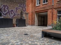 several plants sit in decorative concrete planters along the sidewalk of a building that is very modern