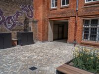 several plants sit in decorative concrete planters along the sidewalk of a building that is very modern