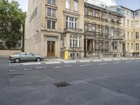 an empty building with signs on the street and people on bikes in traffic passing by