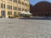 there is a large building in the center of the courtyard with a sidewalk attached to it